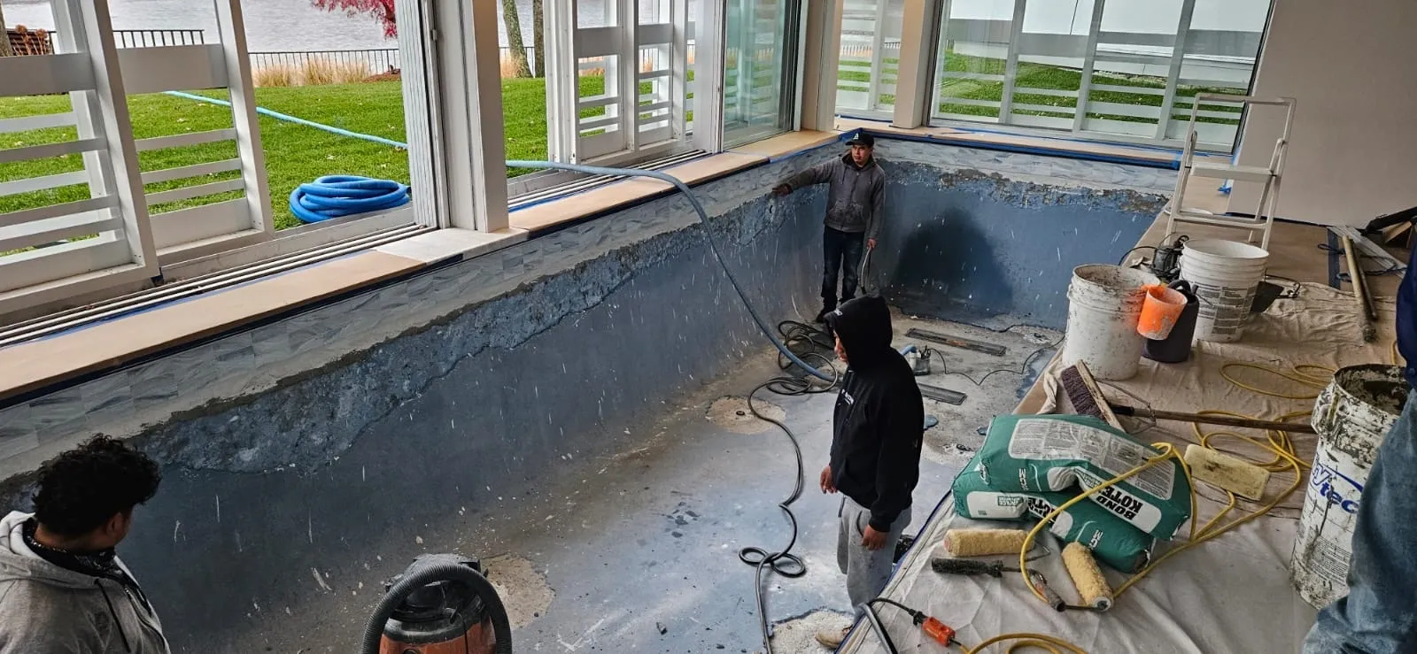 Workers renovating drained indoor swimming pool